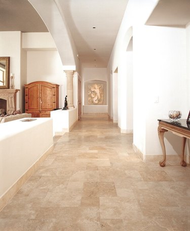 travertine tile baseboards in neutral toned hallway