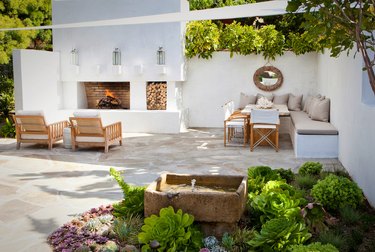 garden with neutral modern decor and white sail shade
