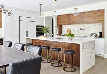 L-shaped kitchen with wood cabinets and waterfall countertop