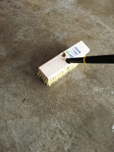 A push broom on a concrete floor.