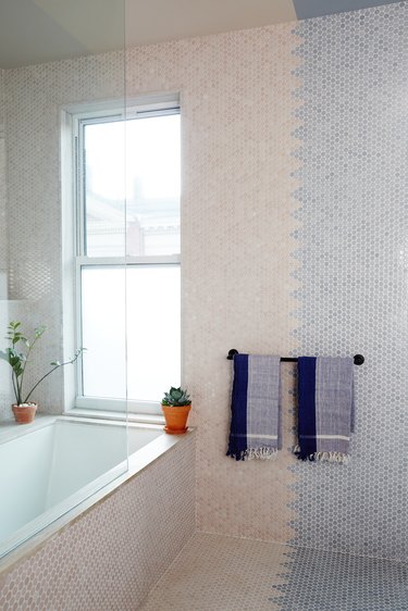 bathroom with beige and blue color blocked penny tile wall with zigzag line
