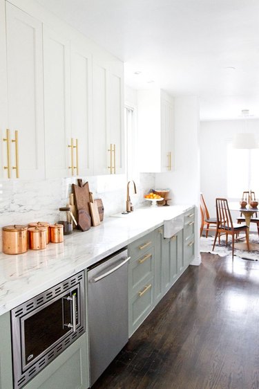modern white kitchen with pastel green accent and brass cabinet pulls