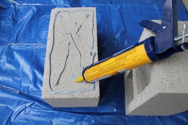 Add concrete adhesive to the first block.