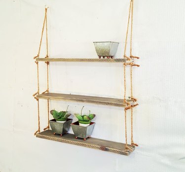 3 floating shelves in reclaimed wood strung together by rope