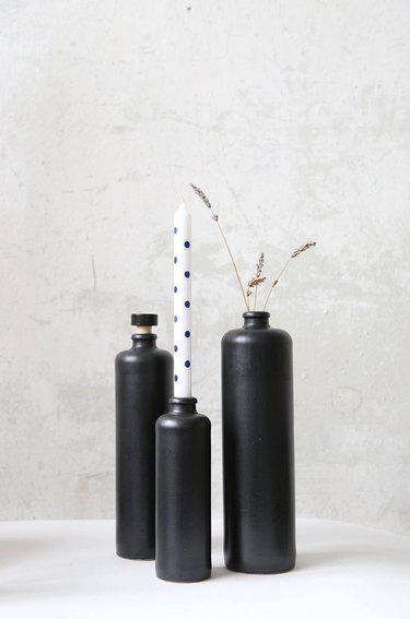 Three matte black cylinder bud vases in varying heights
