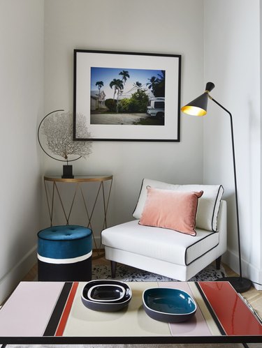 A lounge chair next to a side table with an avant garde globe