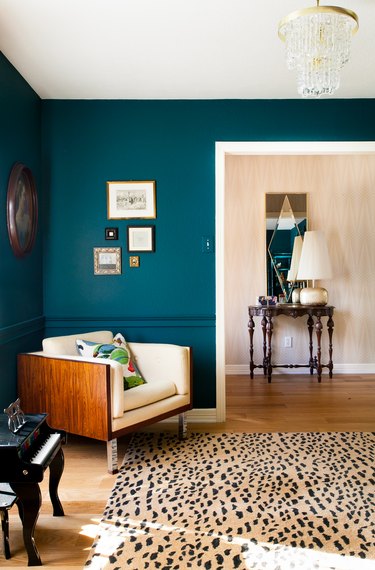 dark greenish blue paint color in sitting room with armchair and patterned rug