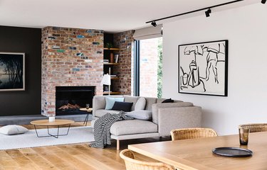 Bright living room with dark wall and brick fireplace.