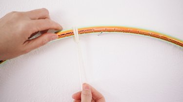 Tying yarn strands onto hula hoop