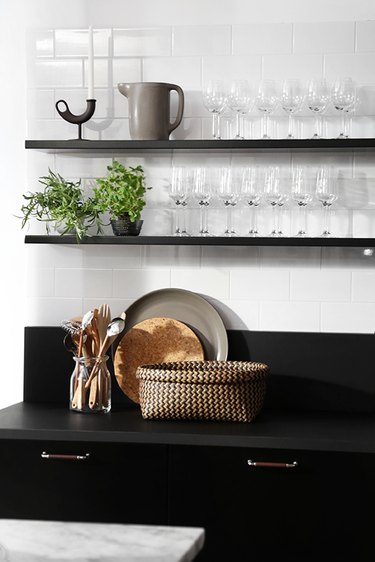 A kitchen with black shelves and countertops.