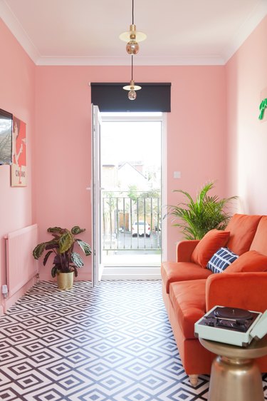 pink living room with red velvet sofa