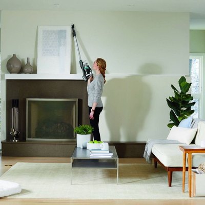 woman vacuuming bright living room with Bissell Icon Pet Stick Vacuum