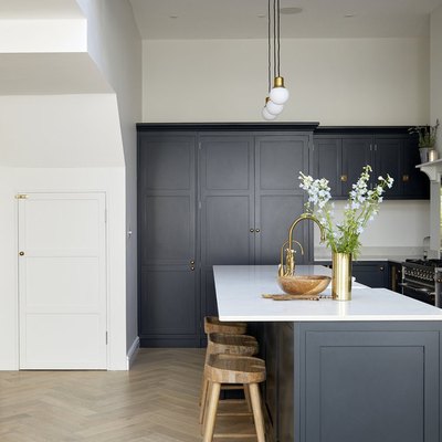 Herringbone kitchen floor with navy blue cabinets and simple decor