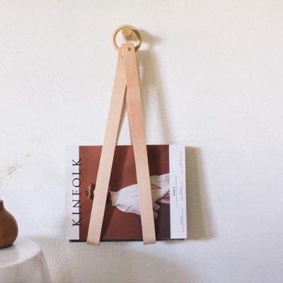 diy leather & wood magazine holder hanging on wall next to wood vase