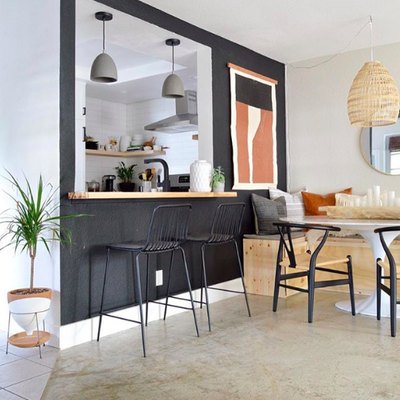 Minimal bohemian dining room with midcentury furniture and black accent wall
