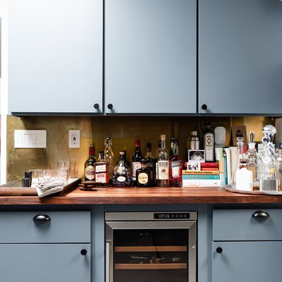 focus on bank of blue cabinets with butcher block counter and wine fridge