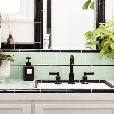 bathroom countertop with blank sink and green and black tiling