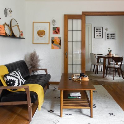 living room space with wooden coffee table and black couch