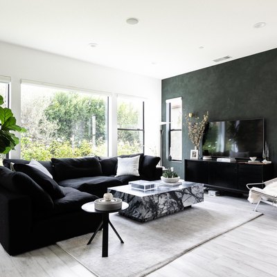 living room with dark walls, dark furniture and light floors