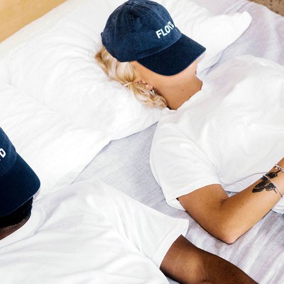 people in bed wearing baseball cap