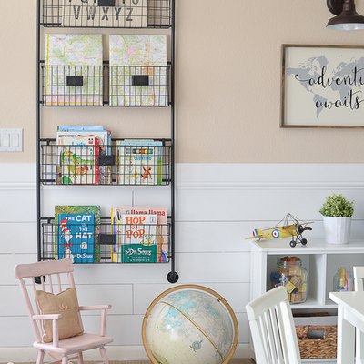 Vertical bookshelf playroom storage idea with blush walls and white furniture