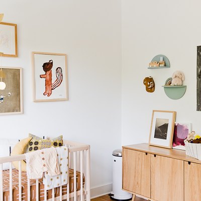 Artistic baby nursery idea with mobile hanging above crib and art on walls
