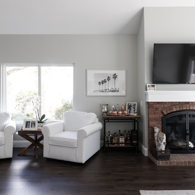 living room with light grey walls, light furniture, and dark floors