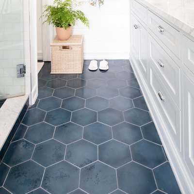 blue tile floor in bathroom with white cabinetry