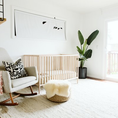 White baby nursery idea with light wood crib and rocking chair