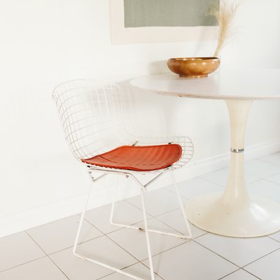 white tile floor beneath mid-century table and wire chair