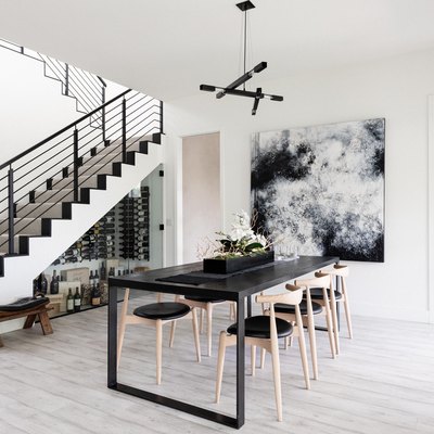 grey monochrome dining room with modern art. view of stair case and hardwood floors