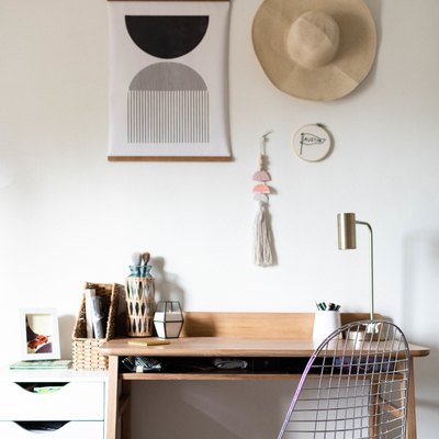 Small home office space with wood writing desk and geometric wall print