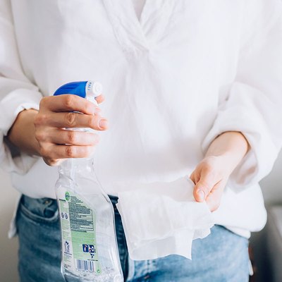 woman holding cleaning spray bottle and paper towel