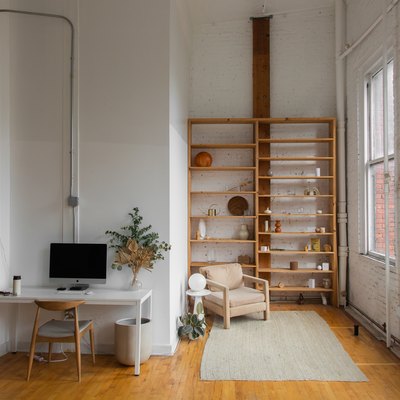 view of minimalist office and bookcase, hardwood floors and wall of windows