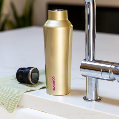 Water bottle near sink faucet and dish towel