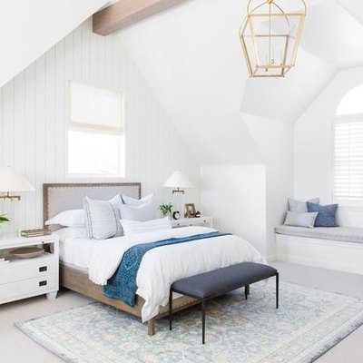 farmhouse style bedroom with white walls and gold chandelier