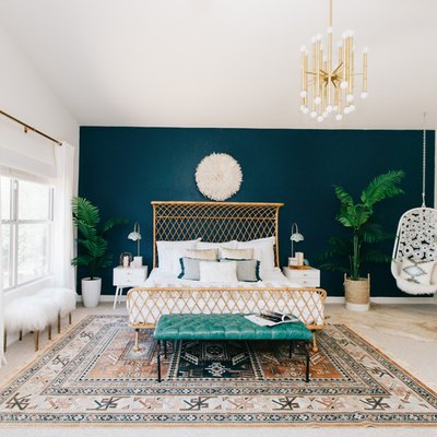 bohemian teal bedroom with feature wall and rattan bed