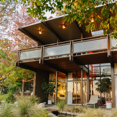 A two-story modern home surrounded by trees