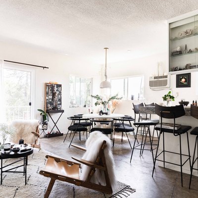 open living space with concrete floors, kitchen, dining table, sheer curtains