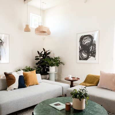 living room with modern sofas, pendant lights, taupe walls, concrete floors