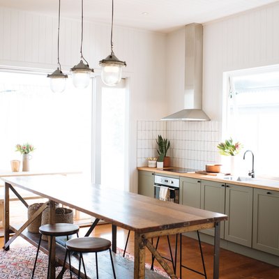 olive green kitchen color idea with wood countertops and pendant lights