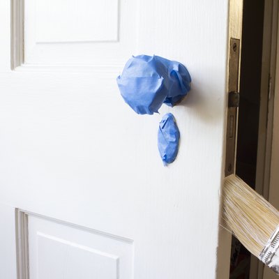 Blue painter's tape on door knob and hand painting side of door