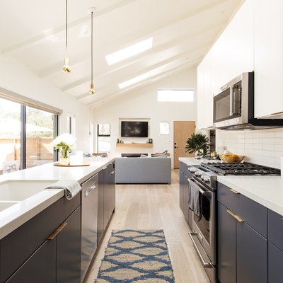 galley kitchen with blue lower cabinets and white countertops