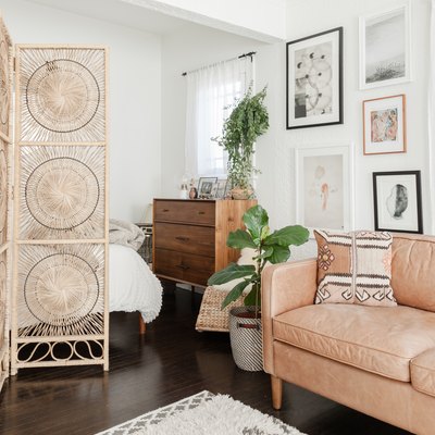Bohemian apartment with rattan room divider and leather couch