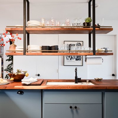 open kitchen with butcher block counter, undermount sink, hanging shelves