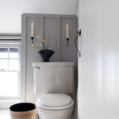 toilet with wall candles above