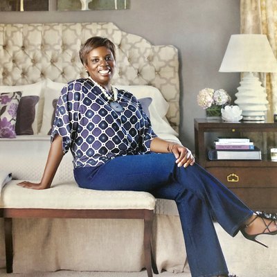 photograph of designer iantha carley sitting on chair near bed