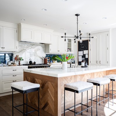 kitchen with white cabinets, decorative wood kitchen island with sink and white stools