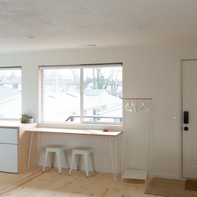 simple minimalist living space with cabinet, large windows, wood floor