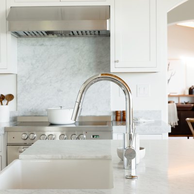 white kitchen island countertop and chrom single-handle kitchen faucet